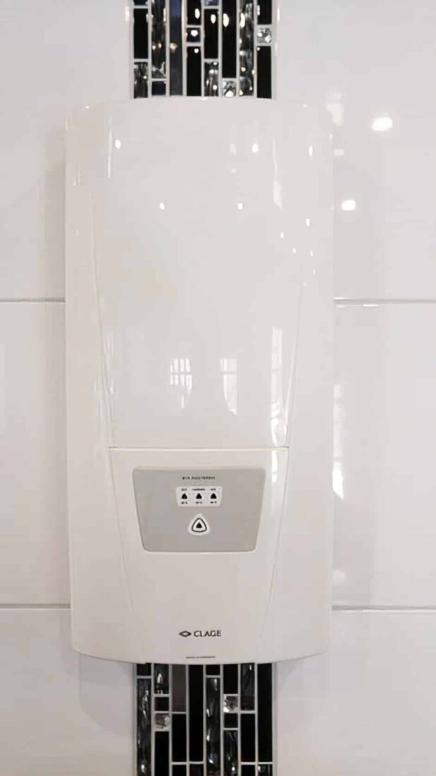 Wand-WC mit Durchlauferhitzer darüber, weißer Handtuchheizkörper und schwarzer Mosaikstreifen – Komplettbad Essen